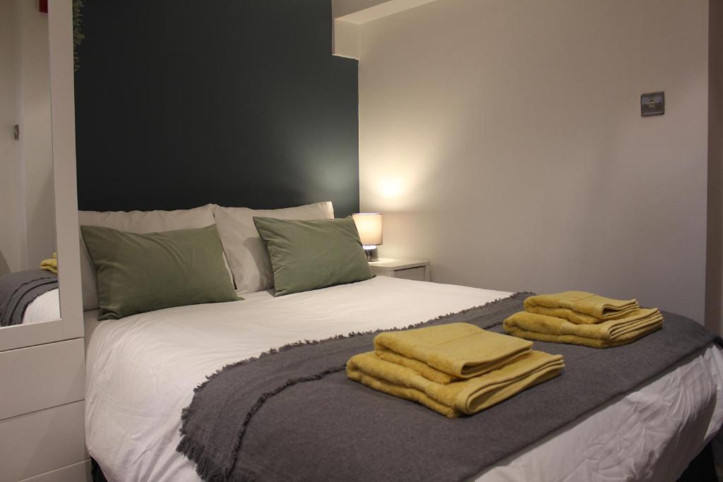 a bedroom with a bed with yellow towels on it at Flat 1, Westhill in Leeds