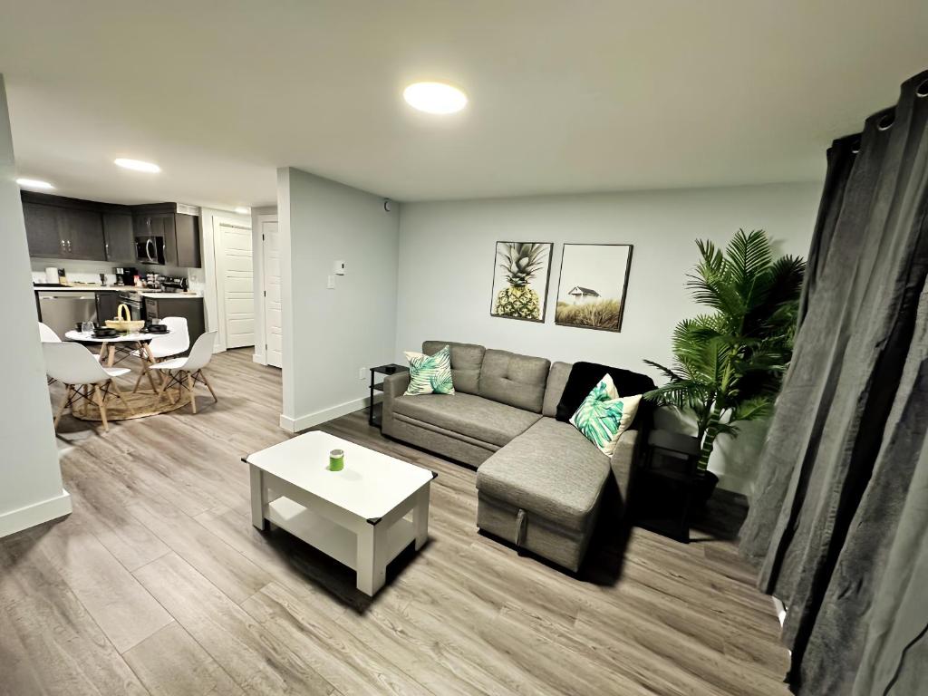 a living room with a couch and a table at Palm Suite St Johns - Luxury One Bedroom Apartment in St. John's