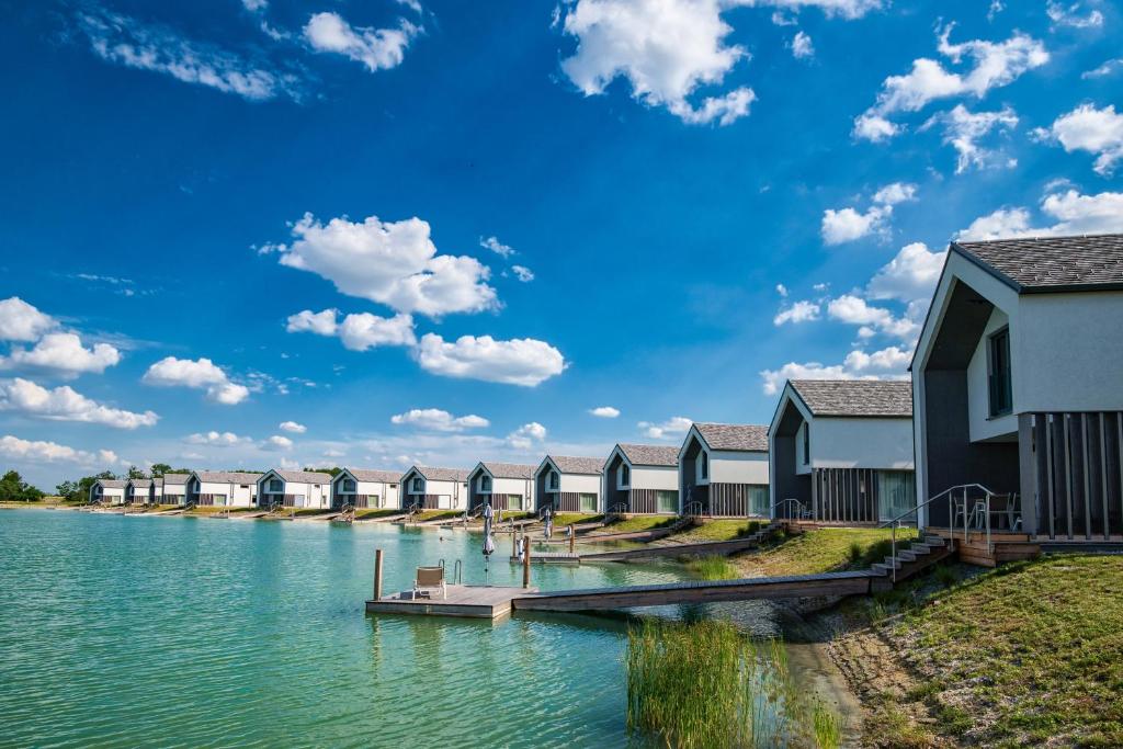 eine Reihe von Häusern auf dem Wasser mit einem Dock in der Unterkunft Vila Vita Pannonia in Pamhagen