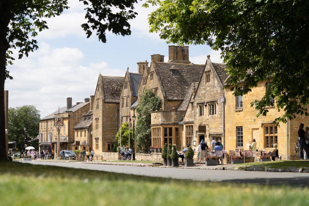 a row of old stone houses on a street at The Lygon Arms - an Iconic Luxury Hotel in Broadway
