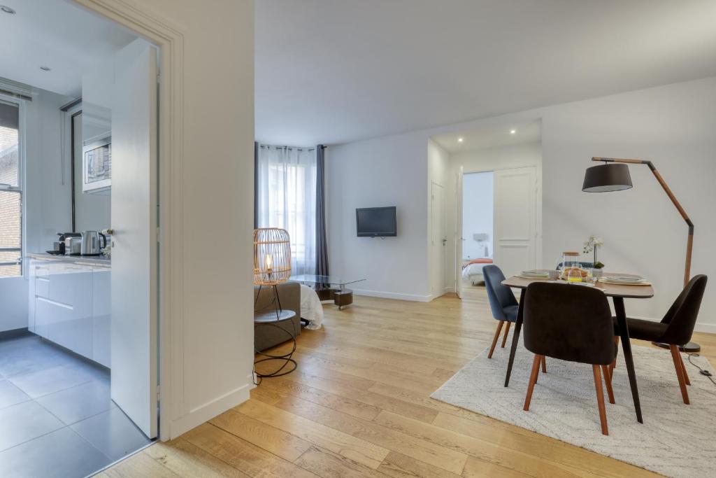 sala de estar con mesa y sillas y cocina en Chic and Warm 1 bd Flat - Heart of the Luxury 16th en París