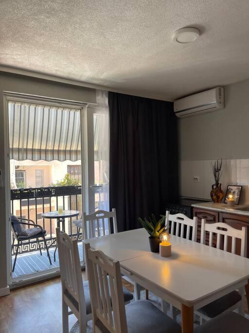 uma sala de jantar com mesa e cadeiras e uma varanda em Etern Stays - Nook Apartment em Pristina