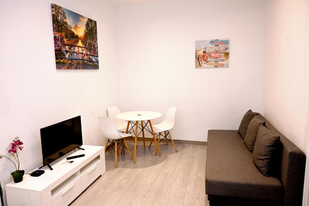a living room with a couch and a tv and a table at Homenfun Barcelona Les Corts in Barcelona