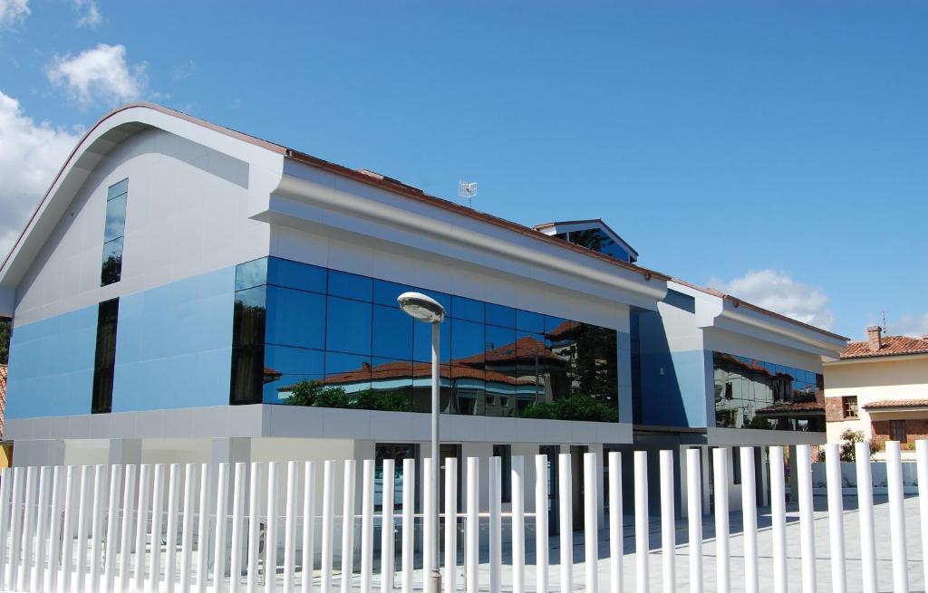 un edificio con una valla blanca delante de él en Hotel Villa Rosario II en Ribadesella