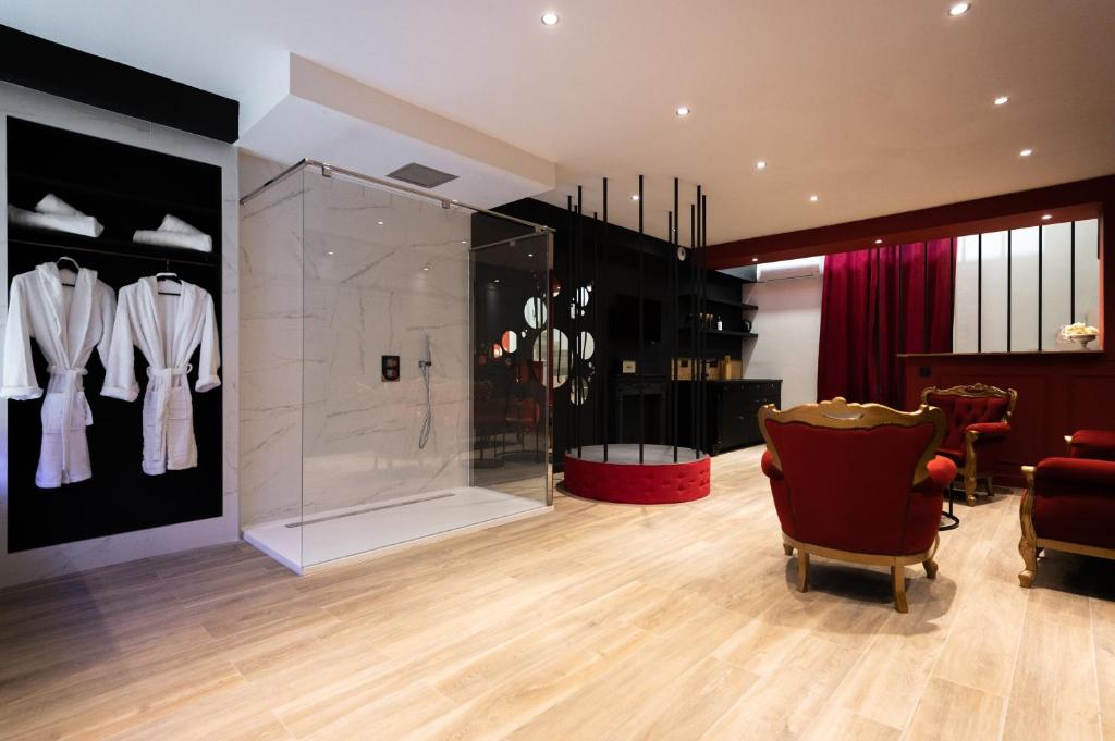 uma sala de vestir com uma caixa de vidro e uma cadeira vermelha em LA PERLE NOIRE em Agde