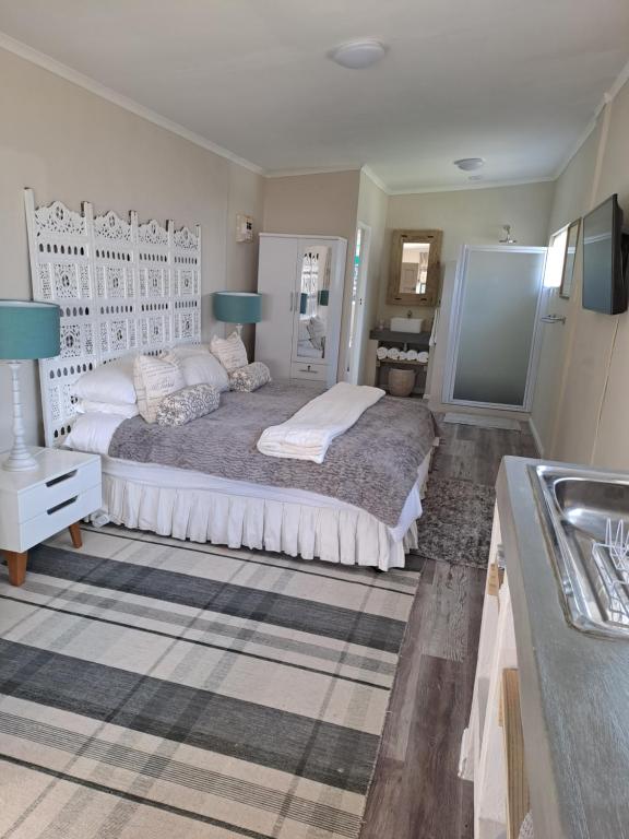 a bedroom with a large bed and a sink at Milky Way in Hermanus