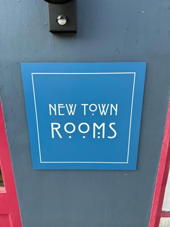 een bord op een muur met nieuwe stadskamers bij New Town Rooms in Edinburgh