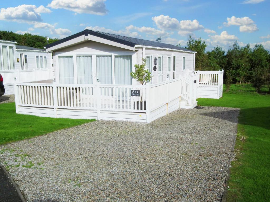 a white mobile home with a white fence at No 4 Fistral in Newquay