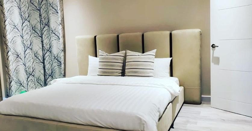 The Island Experiences Luxury Villa في Choiseul: غرفة نوم بسرير ذو شراشف ووسائد بيضاء
