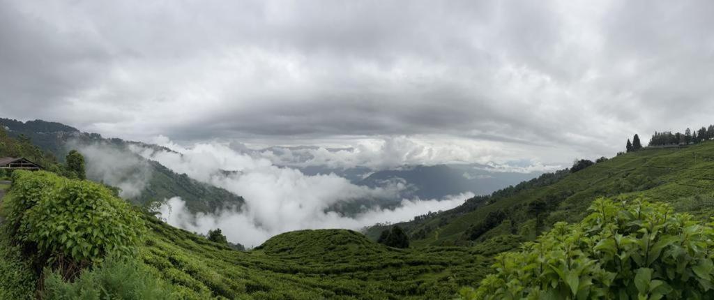 una vista de una montaña con nubes en el valle en Athithi homestay, en Darjeeling