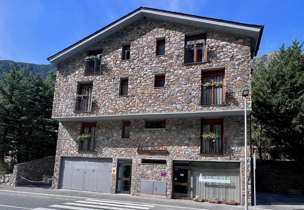 ein großes Steingebäude mit Fenstern auf einer Straße in der Unterkunft Apartaments Turistics El Buner in Ordino