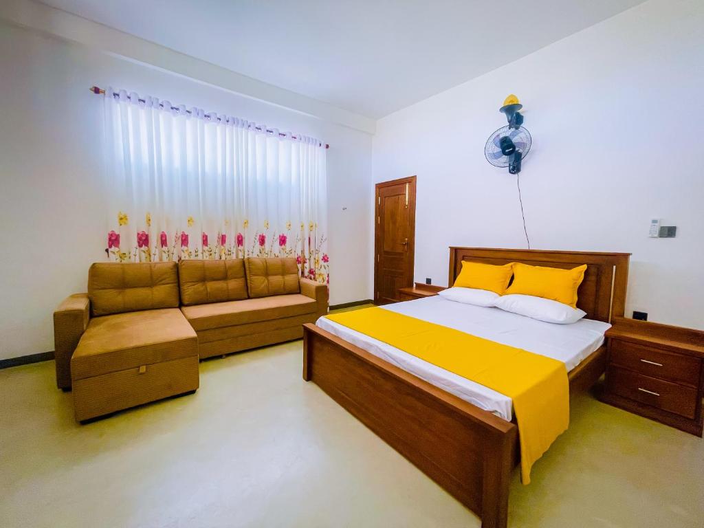 FARONA Beach Villa في أمبارا: غرفة نوم بسرير واريكة