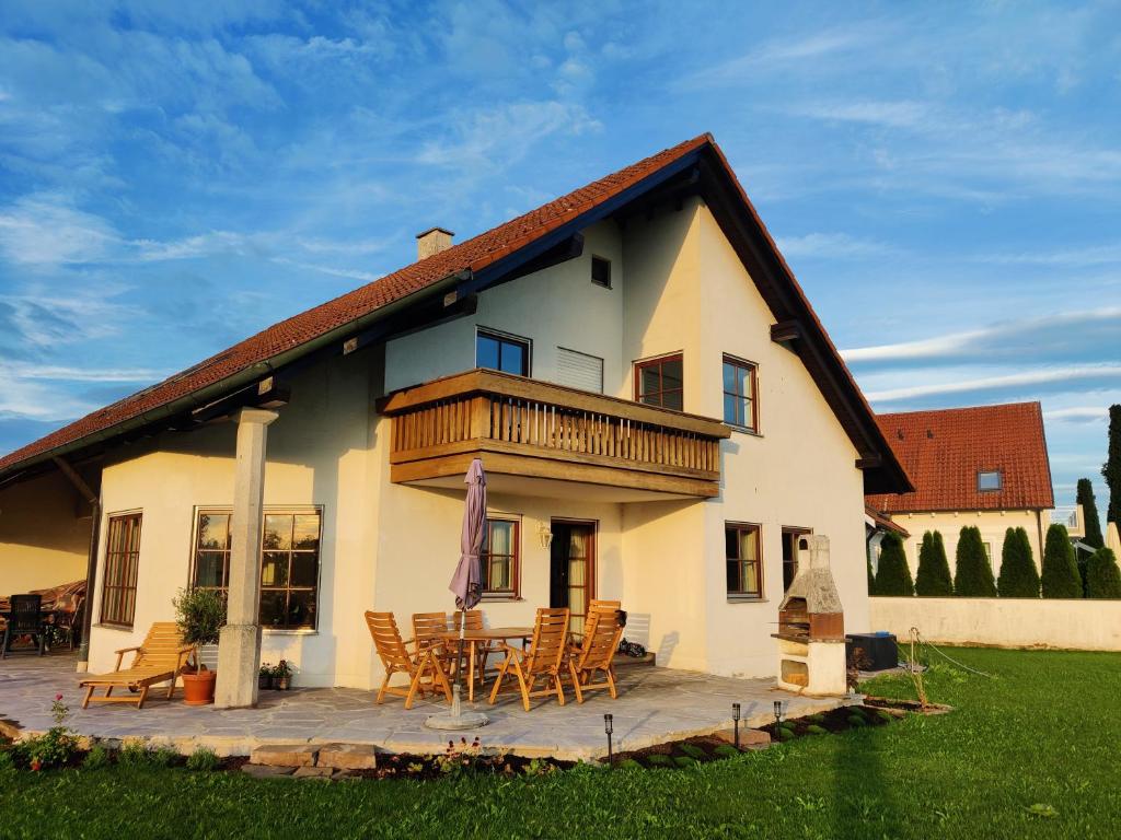 Casa blanca grande con terraza y sillas en Richie's Landhaus im Allgäu, en Pfaffenhausen