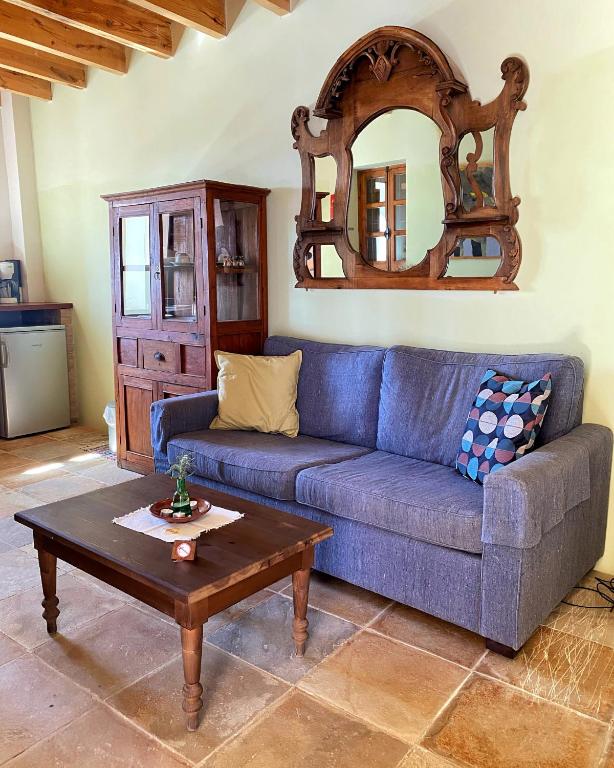 a living room with a blue couch and a table at Eveleos Country House in Tochni