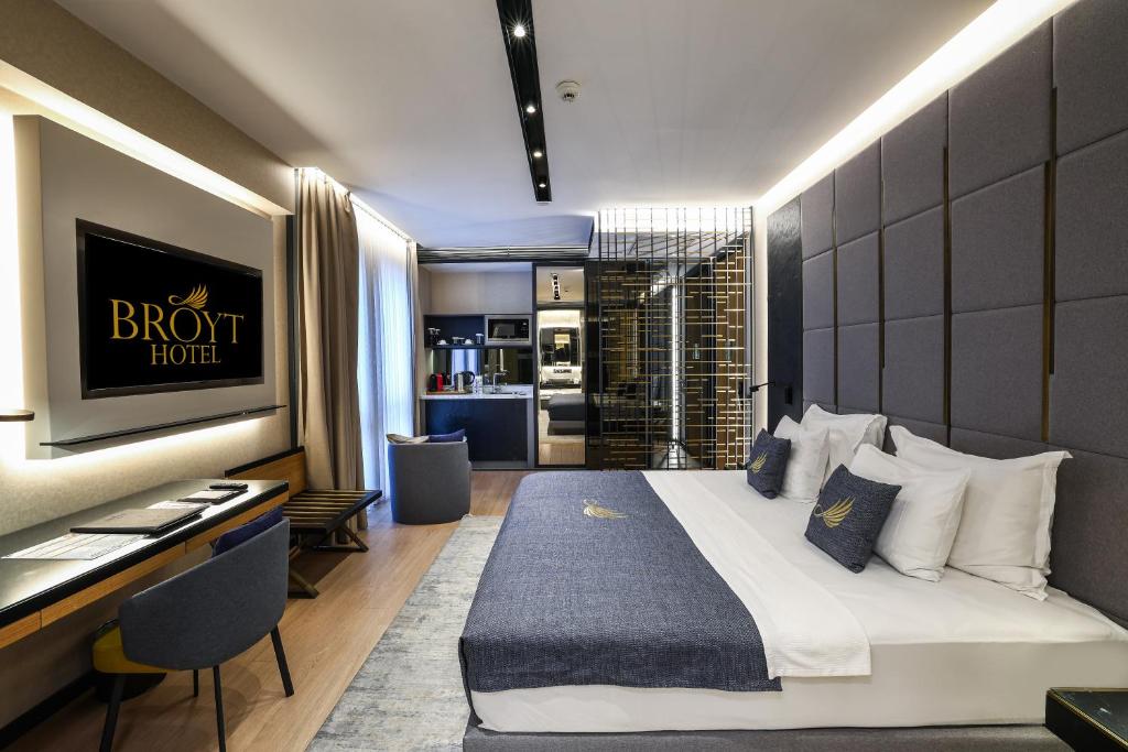 um quarto de hotel com uma cama, uma secretária e uma cozinha em Broyt Hotel em Istambul