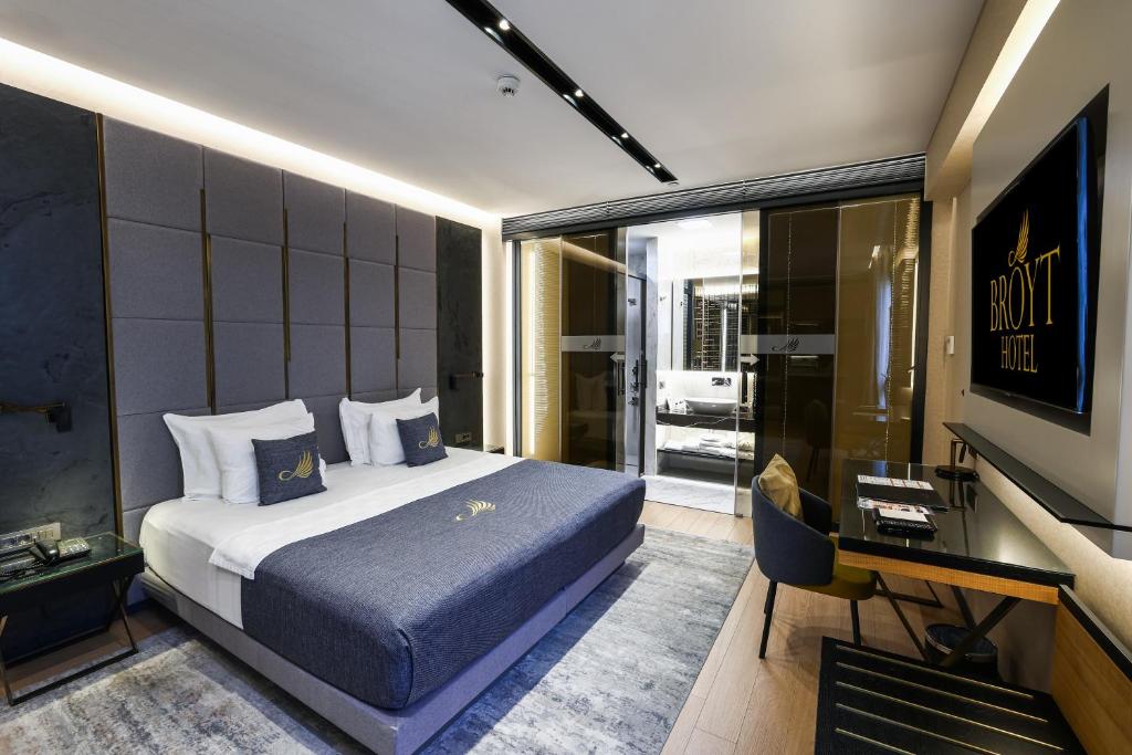 a bedroom with a bed and a desk and a television at Broyt Hotel in Istanbul