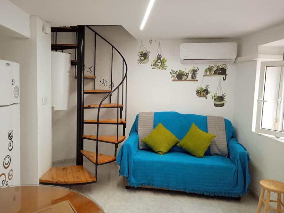uma sala de estar com um sofá azul e uma escada em espiral em Casa Cris Cazorla Oldtown II em Cazorla