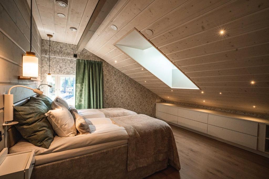 a bedroom with a large bed with a skylight at Villa Pöylikki in Rovaniemi