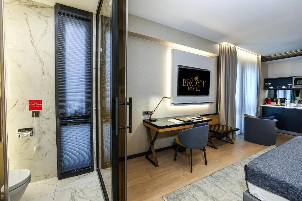 a hotel room with a desk and a bedroom at Broyt Hotel in Istanbul