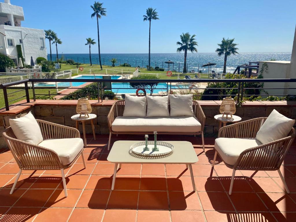 een patio met stoelen en een tafel met uitzicht op de oceaan bij LUXURY Casares del Mar DBJ11 in Casares