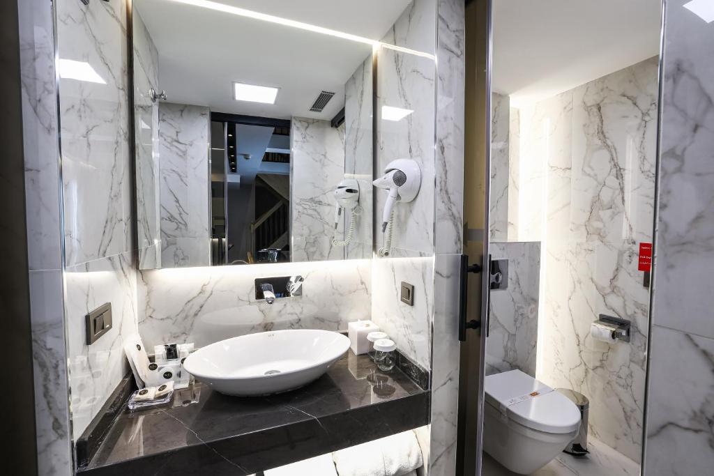 a white bathroom with a sink and a toilet at Broyt Hotel in Istanbul