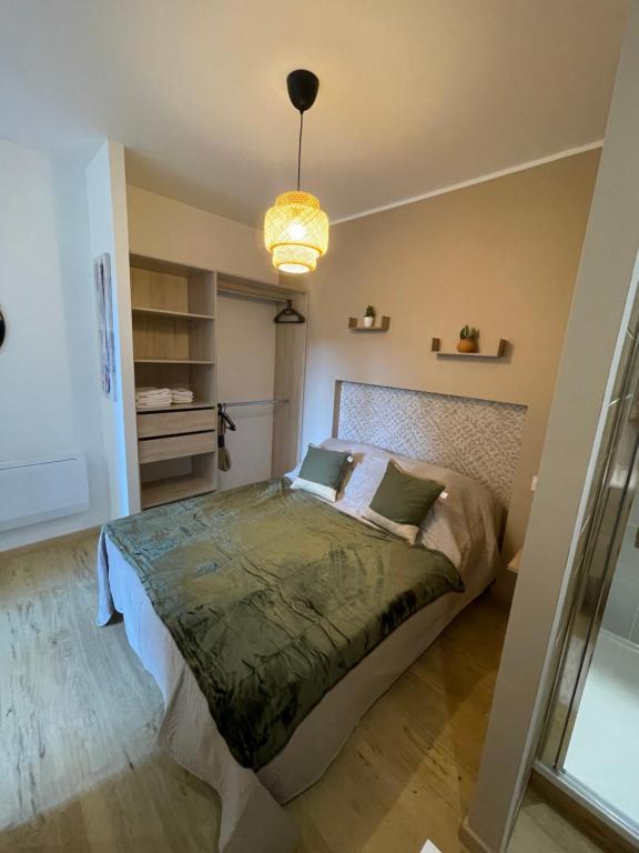 1 dormitorio con 1 cama con edredón verde en Au 35, en Millau
