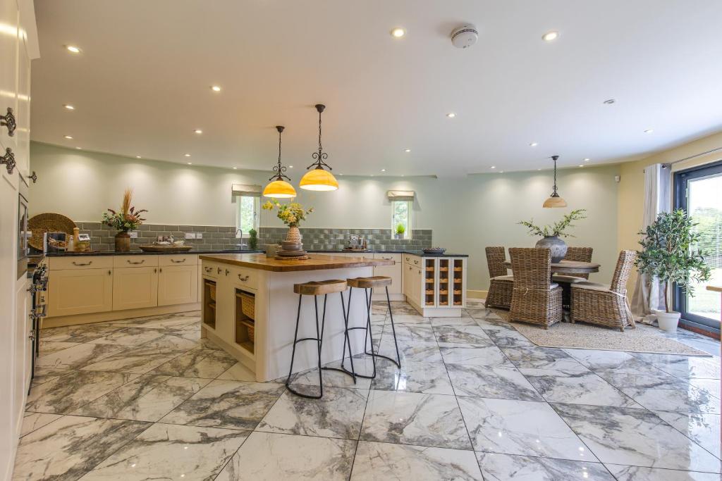 a kitchen with a large island with bar stools at Stylish 5bed with parking and large garden in Norwich