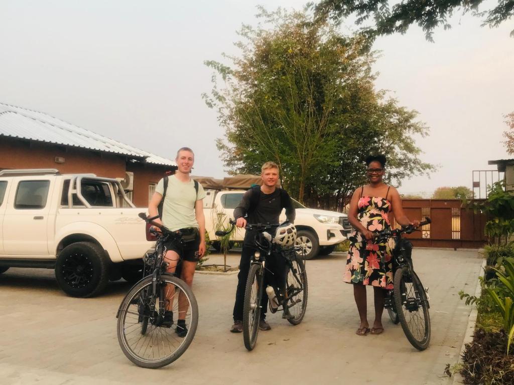 un grupo de tres personas de pie con sus bicicletas en Jayla Apartment, en Maun
