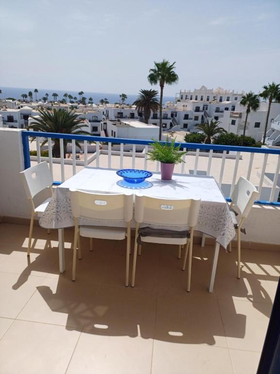 una mesa blanca y sillas en un balcón con vistas al océano en T2 RESIDENCE ATALAYA PUERTO DEL CARMEN LANZAROTE, en Puerto del Carmen
