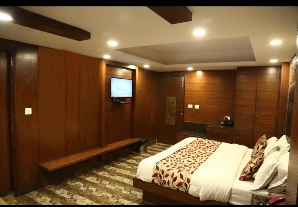 a hotel room with a bed and a flat screen tv at Hotel Hamers International in Mussoorie