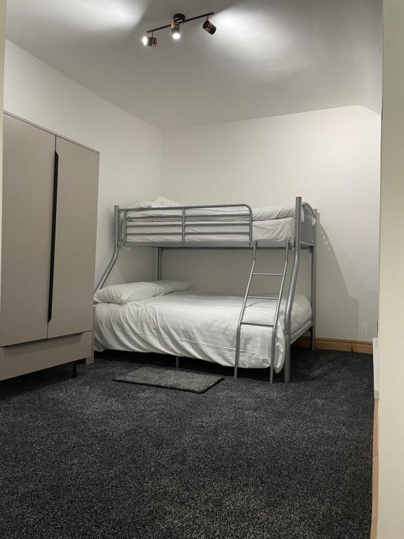 a bedroom with a bunk bed in a white room at Seaside paradise in Bon-y-maen