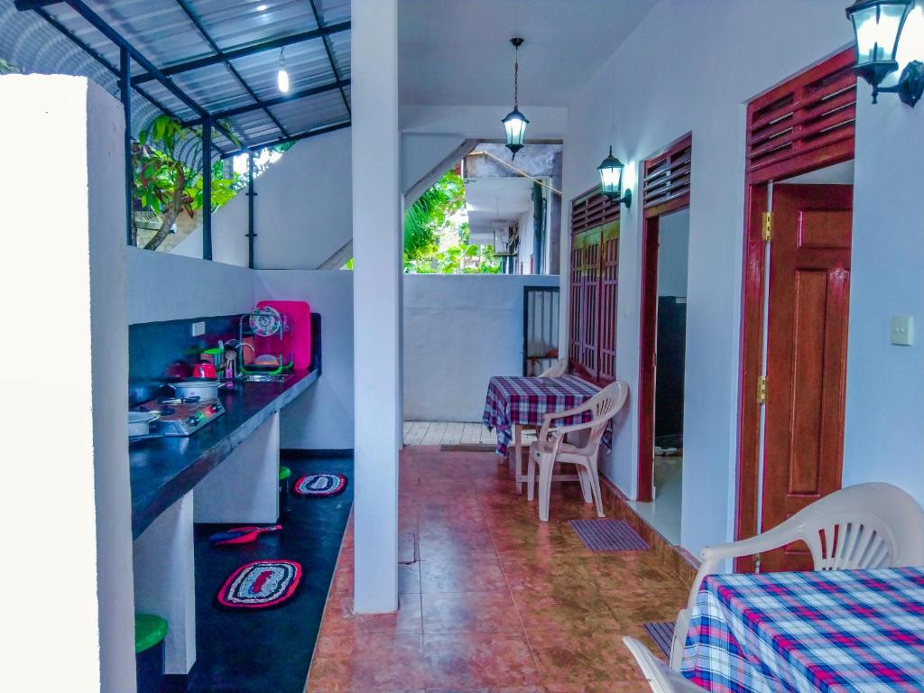 a kitchen and dining room with a table and chairs at Bloom Guest House in Mirissa