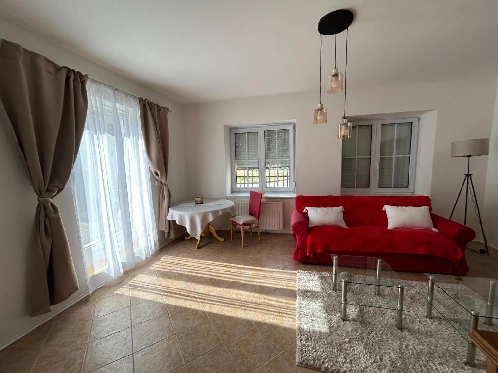 a living room with a red couch and a table at Apartmán Svítkov 21 in Pardubice