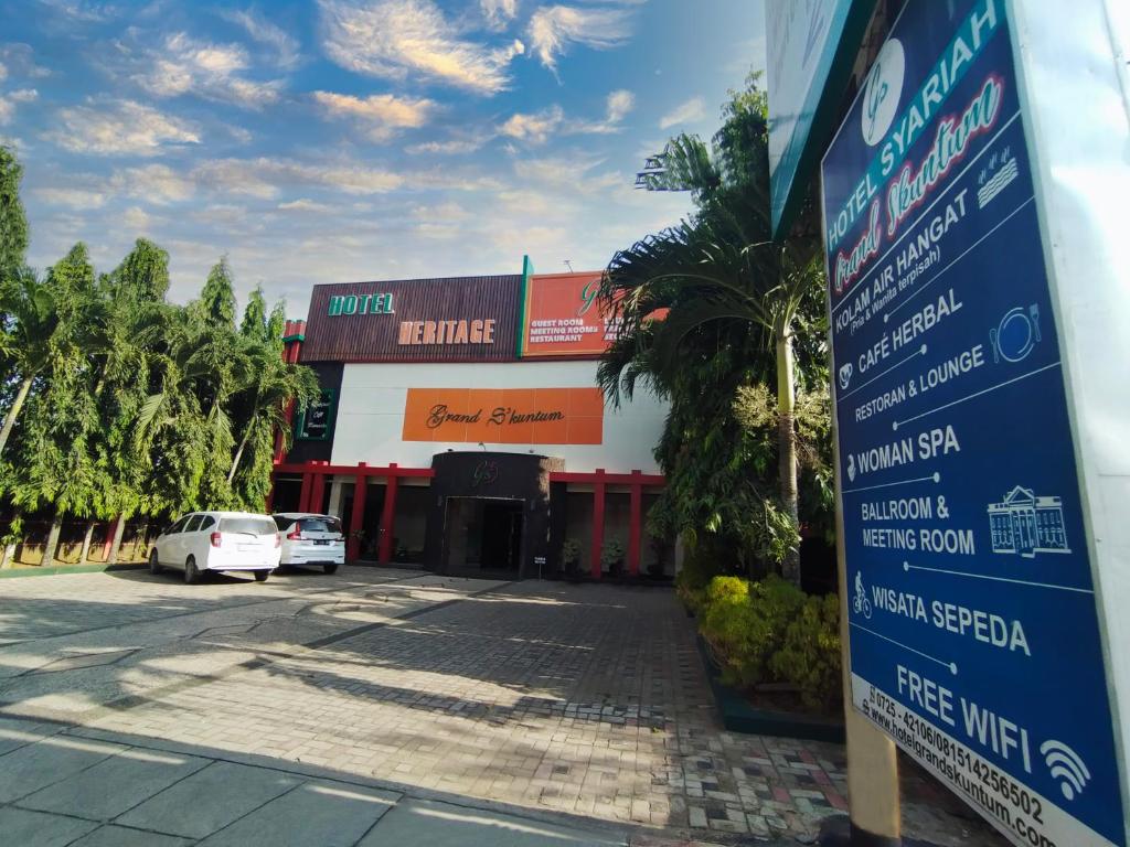 un panneau devant un bâtiment avec un parking dans l'établissement Grand S'kuntum Hotel Syariah, à Metro