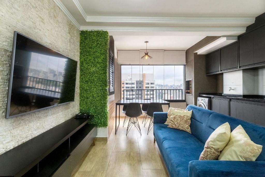 uma sala de estar com um sofá azul numa cozinha em Piscine Resort - Um Oasis no centro de SP | Canal do Anfitrião em São Paulo