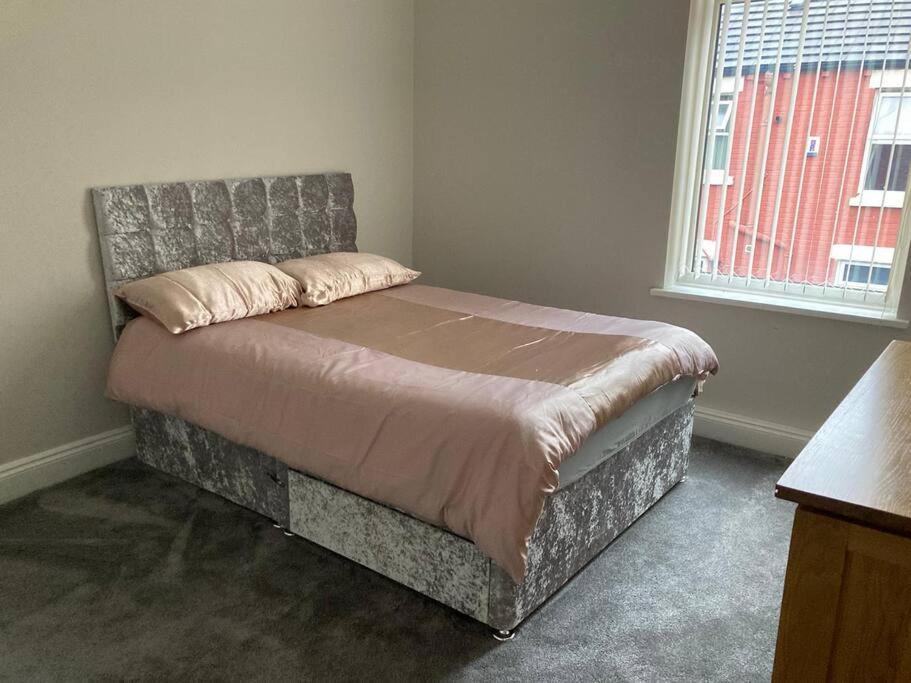 a bedroom with a bed with a headboard and a window at City and football in Liverpool