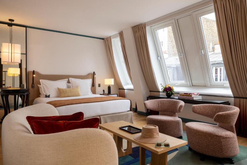 een hotelkamer met een bed en twee stoelen bij Hôtel Bel Ami in Parijs