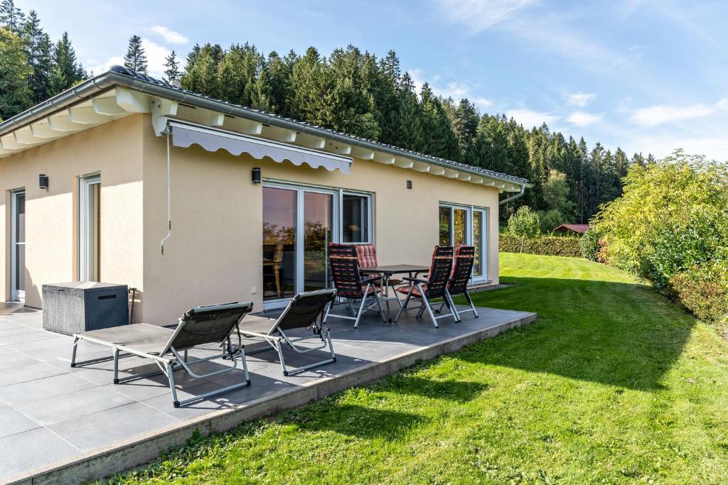 a patio with chairs and a table in front of a house at Tischneck Chalets in Hardt