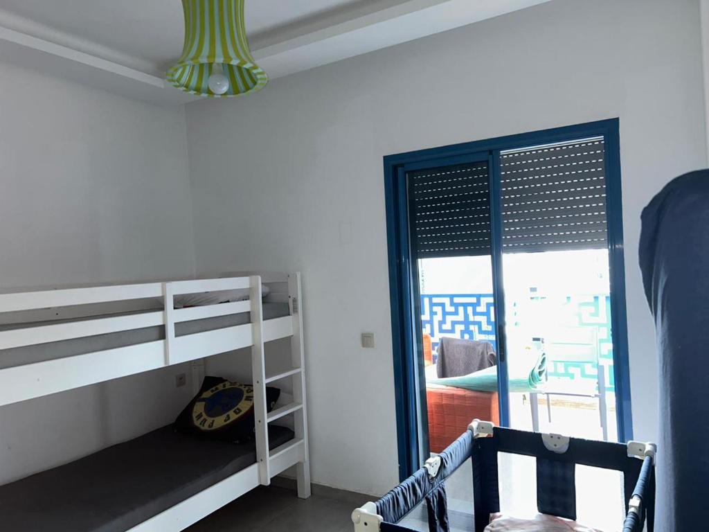 1 dormitorio con litera y ventana en Costa Mar , avenue Miramar en Martil