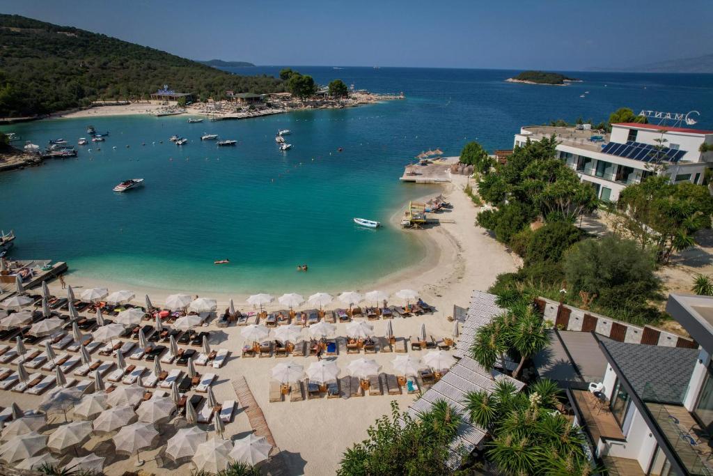 uma vista aérea de uma praia com cadeiras e guarda-sóis em HOTEL DENOEL em Ksamil