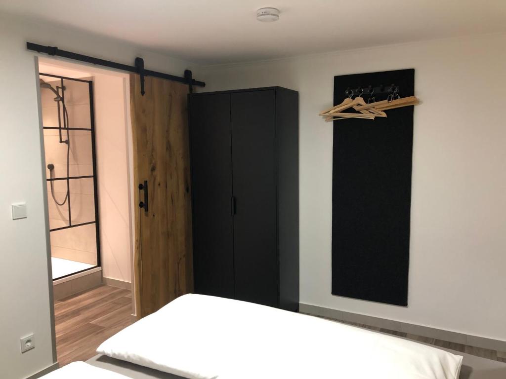 a bedroom with a bed and a black cabinet at Hotel Weilerhof in Dormagen