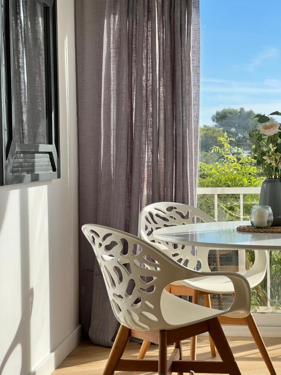 a table and two chairs in a room with a window at PARAISO DEL SOL in Benajarafe