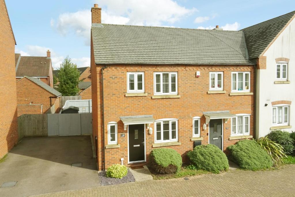 a brick house with white windows and a driveway at Park view house, sleeps 5 or 6 suitable for contractors and families in Kibworth Harcourt