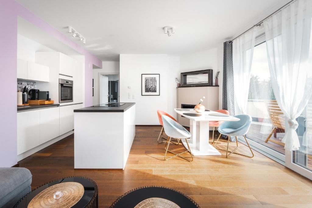 a kitchen and living room with a table and chairs at Kaiser Apartments - Wohnpark Graz-Gösting in Graz
