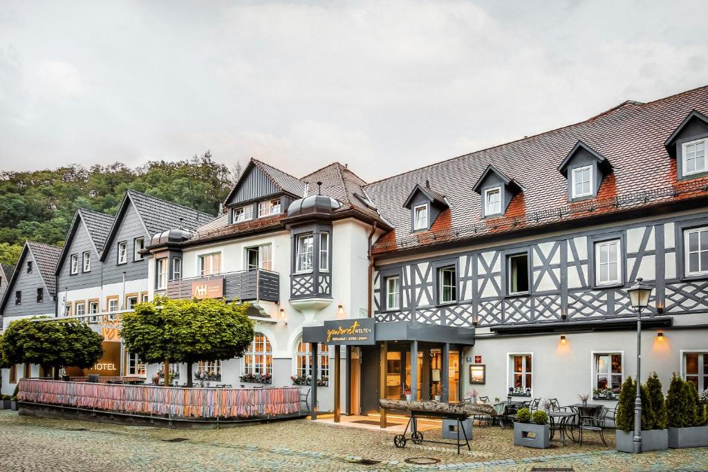 een rij witte gebouwen met zwarte daken bij Posthotel Alexander Herrmann in Wirsberg