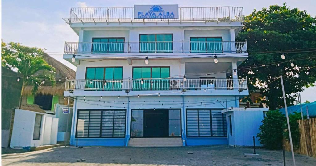 - un grand bâtiment avec un balcon en haut dans l'établissement Playa Alba Beach Front and Resort, à San Antonio