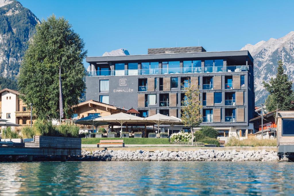 - un grand bâtiment à côté d'une étendue d'eau dans l'établissement Seehotel Einwaller - adults only, à Pertisau