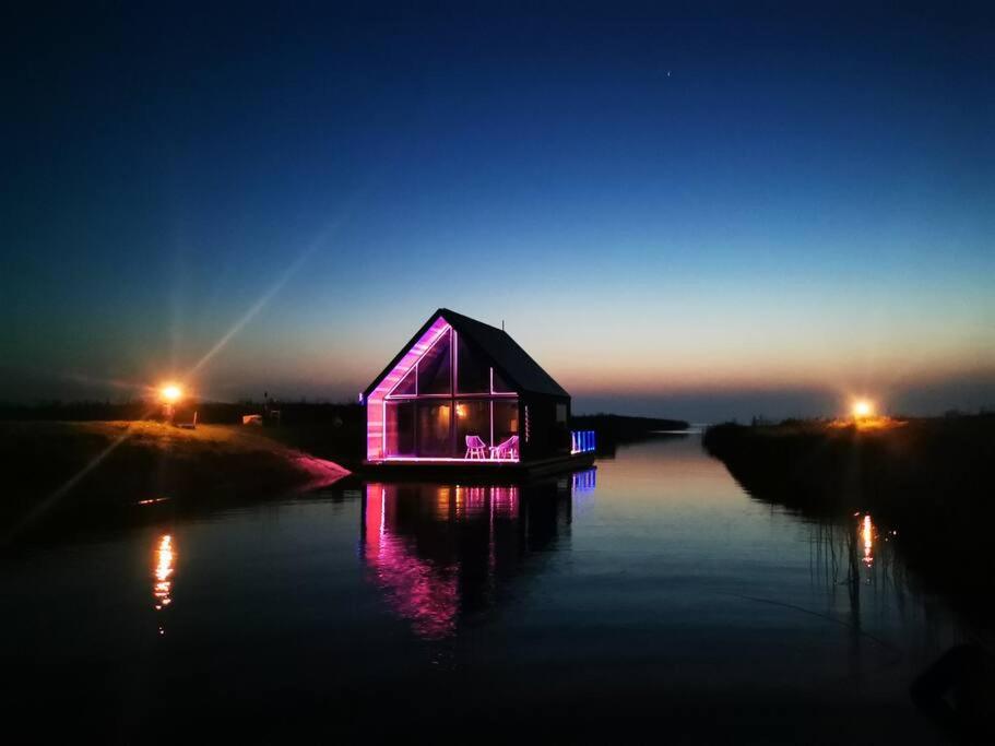 a small house on the water at night at Feel the breeze - cozy luxury in Elva