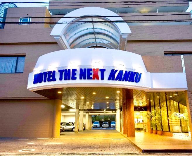 a building with a sign that reads wild the next killing at HOTEL THE NEXT KANKU in Sennan