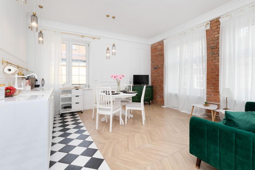 a kitchen and living room with a table and chairs at Trendy Apartment Chlebnicka in The Heart of Gdańsk Old Town by Renters in Gdańsk